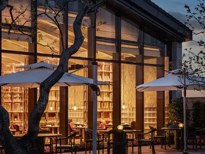 Modern restaurant exterior with glass walls at dusk