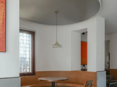Industrial-themed restaurant seating area with wooden benches and a round table.