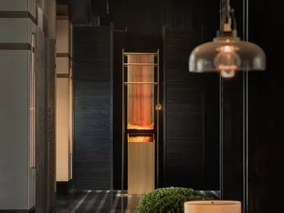 Cozy modern hotel lobby with wooden paneled walls and warm lighting.