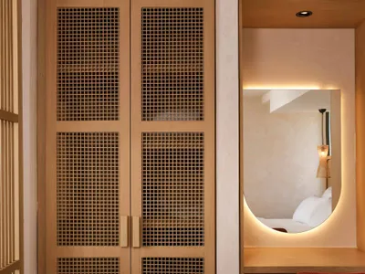 A minimalist bedroom with wooden furniture and a white bed.