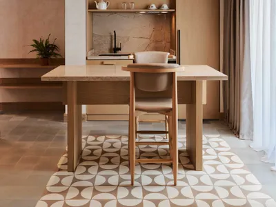 Modern kitchen with wooden countertop and marble backsplash, featuring a pendant light with a woven texture