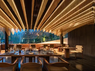 Modern restaurant interior featuring metallic lighting chains and a contemporary design.