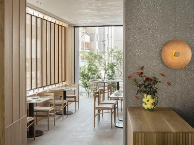Modern restaurant interior showcasing contemporary design with wooden materials and sleek, minimalist decor.