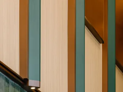 A modern staircase with metal railings and green and brown tiles