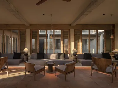 Modern minimalist living room with concrete floors, wooden furniture, and floor-to-ceiling windows.