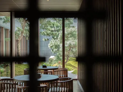 A modern restaurant cafe interior featuring wooden tables and chairs.