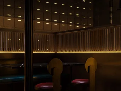 A modern industrial restaurant interior with wooden furniture and lighting.