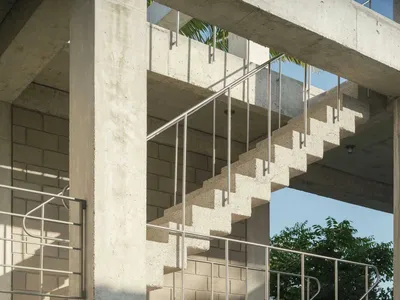 現代建築空間中的混凝土樓梯，搭配金屬扶手。