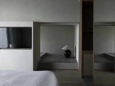 Minimalist bedroom with concrete floor and wood accents