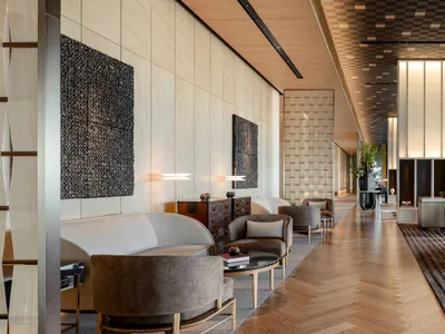 A modern hotel lobby featuring wood, glass, and metal materials