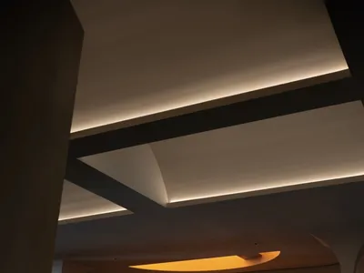 Modern hotel lobby with a reception counter made of polished marble, featuring elegant curved lighting fixtures and a warm, i