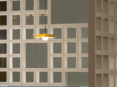 A modern restaurant booth with blue upholstery and metal accents, featuring a yellow pendant light and a glass wall