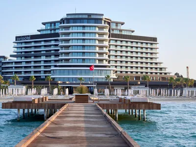 Modern hotel buildings with glass facades and wooden decks on the Adriatic Sea.