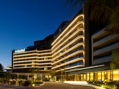 Swissotel 飯店建築夜間燈光照亮，呈現現代建築設計。