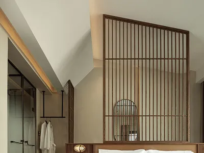 A minimalist bedroom featuring a wooden bed with white bedding and a bamboo partition.