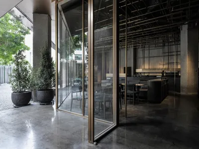現代簡約餐廳室內採用混凝土材質，呈現俐落工業風格。
