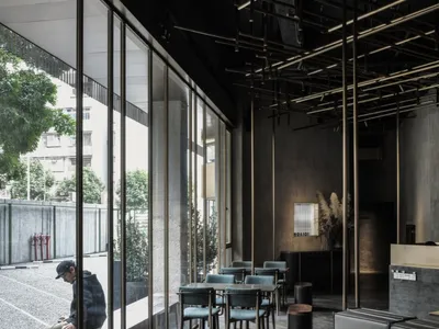 現代工業風餐廳室內，採用金屬與混凝土元素，並搭配大型窗戶。