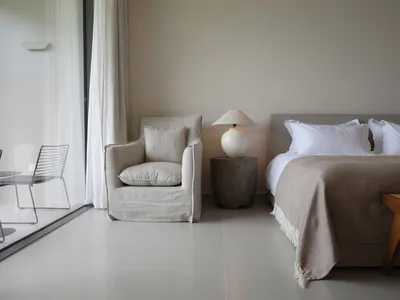 Minimalist bedroom featuring neutral-toned textiles and furniture