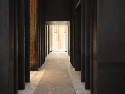 現代酒店走廊，鋪設大理石地板與黑色木質牆面