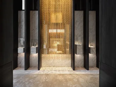 A modern hotel lobby featuring a gold metal chain lighting fixture