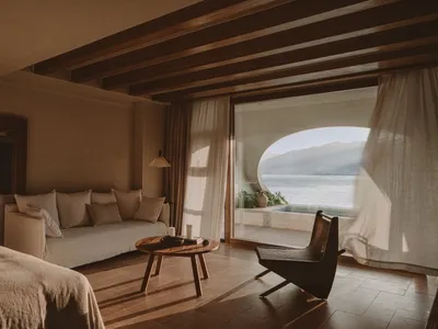 A minimalist bedroom featuring curtains and wooden furniture.