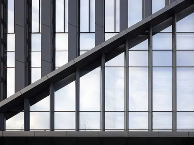 Modern glass facade of a hotel with large windows and a sign that reads 'RESORT HOTEL'.