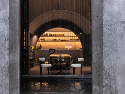 A modern dining room with a concrete and glass palette