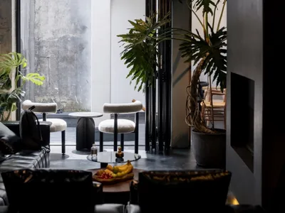 A modern restaurant lounge with concrete, leather, and glass materials.