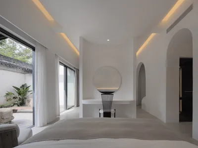 Modern minimalist bedroom with concrete finishes, large windows, and organic elements.