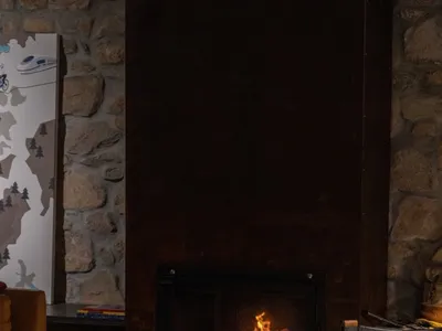 A cozy living room with a large stone fireplace and comfortable seating arrangements.