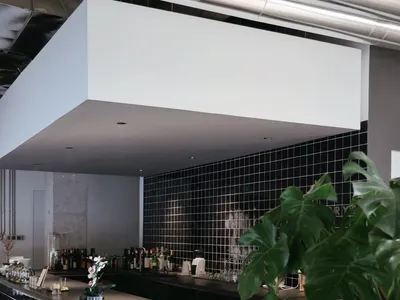 Modern interior of a restaurant bar with black and white tile accents and a minimalist design.
