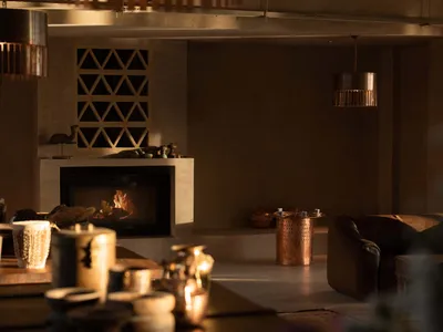 Industrial-style living room featuring a concrete fireplace and warm, ambient lighting.