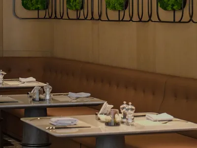 Modern restaurant interior with green living walls and metallic fixtures.