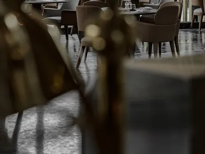 A modern restaurant interior with tables, chairs, and decorative elements arranged in a dining setting.