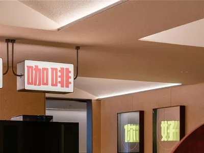 Industrial-style restaurant interior with tile and concrete counter, featuring red stools and a sign with Chinese characters.