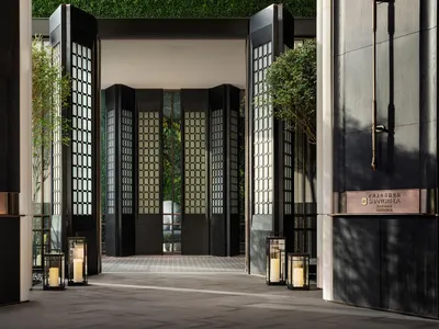 Modern hotel entryway featuring black glass and wooden panels
