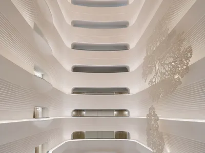Modern hotel lobby with white marble, glass, and metal accents