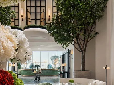 Luxurious hotel lobby with modern decor, concrete walls, glass walls, and greenery