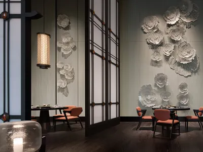 An elegant, modern restaurant interior featuring metallic floral wall art and dark wood flooring.