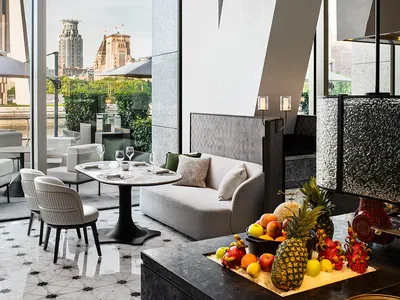 Modern restaurant bar with marble floor, glass walls, and concrete accents
