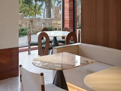 Modern restaurant interior with marble seating and white flooring.
