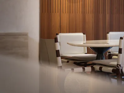 Modern restaurant interior with white leather chairs and wooden paneling wall