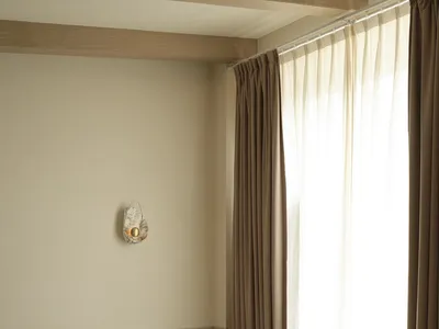 A modern, minimalist bedroom featuring a concrete bathtub and floor-to-ceiling curtains.