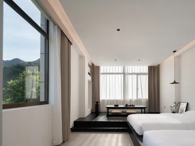 現代簡約臥室呈現乾淨的白色設計，搭配落地窗簾與木質地板。