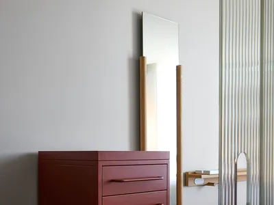 A minimalist bedroom features a metal dresser with drawers and a cabinet.