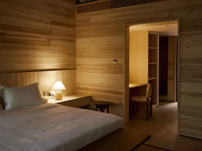 Minimalist bedroom featuring wooden walls and a cozy atmosphere
