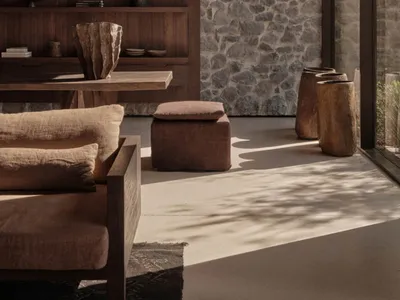 A cozy, rustic industrial living room with stone, concrete, and reclaimed wood elements.