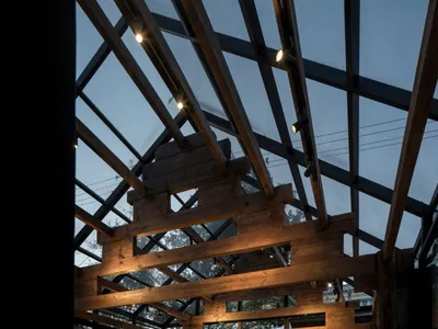Industrial-style restaurant with wooden beams and glass ceiling.