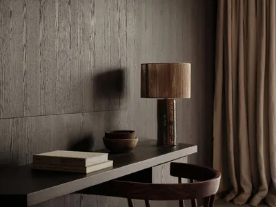 A modern home office desk with a wooden chair, lamp, and a few books.