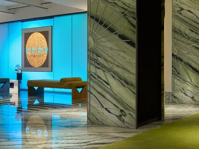 Modern hotel lobby featuring marble walls and glass elements.